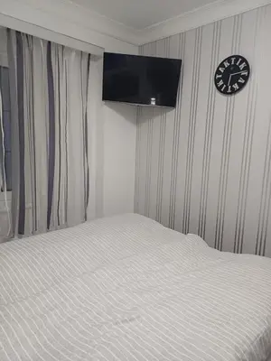 a bedroom with a bed and a clock on the wall at Apartman Dolly Vrnjacka banja in Vrnjačka Banja