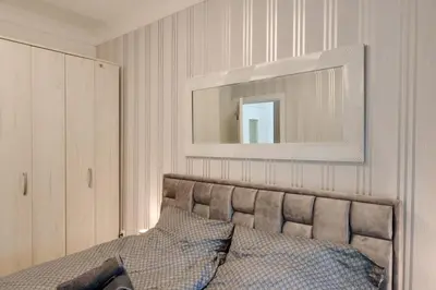 a bedroom with a bed with a mirror above it at Apartman Dolly Vrnjacka banja in Vrnjačka Banja