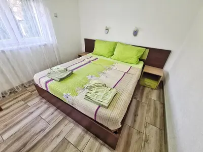 a bedroom with a bed with green pillows on it at Vila Aleksandra 2 Apartman 6 in Soko Banja