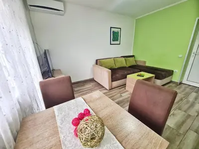 a living room with a table and a couch at Vila Aleksandra 2 Apartman 6 in Soko Banja