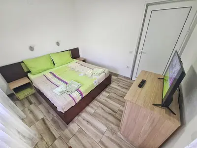 a bedroom with a bed with a television in it at Vila Aleksandra 2 Apartman 6 in Soko Banja
