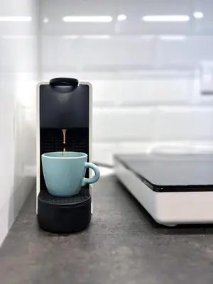 a coffee maker with a cup on a counter at Oaza Kopaonik in Kopaonik