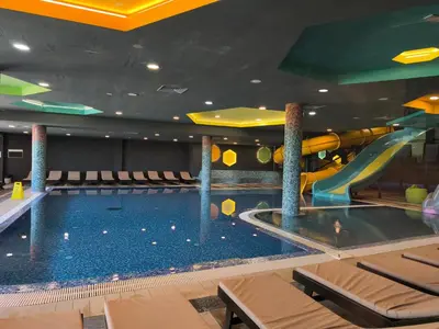a pool with a slide in a hotel room at Oaza Kopaonik in Kopaonik