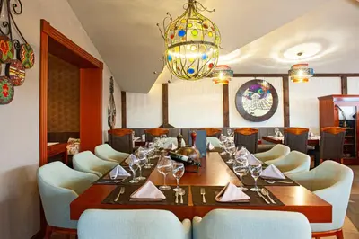 a dining room with a table and chairs and a chandelier at Oaza Kopaonik in Kopaonik