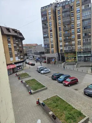 a parking lot with cars parked in front of tall buildings at Anastasija Lux 2 in Paraćin