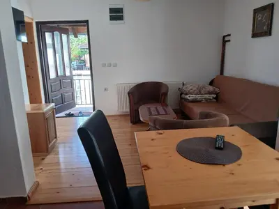 a living room with a table and a couch at Kuća za odmor in Bukorovac