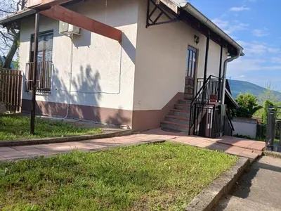 a house with a porch and stairs in front of it at Kuća za odmor in Bukorovac