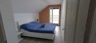 a bedroom with a blue bed with a teddy bear on it at Vila Piramida - Zavojsko jezero-Pirot in Bukorovac
