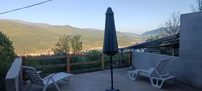 a patio with two chairs and an umbrella at Vila Piramida - Zavojsko jezero-Pirot in Bukorovac