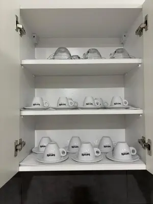 a shelf filled with white tea pots and teapots at Apartman Kostić in Niš