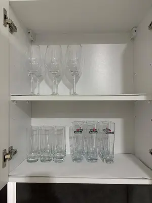 a row of wine glasses sitting on a shelf at Apartman Kostić in Niš