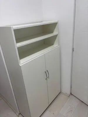 a white closet with white shelves and a door at Apartman Kostić in Niš