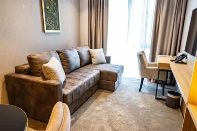 a living room with a brown couch in a room at Hotel Helm in Niš