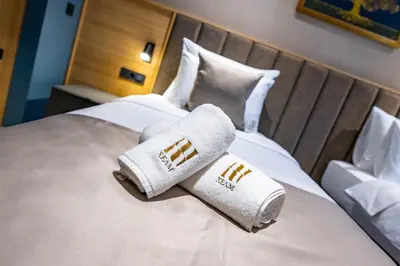 a hotel room with two towels on a bed at Hotel Helm in Niš