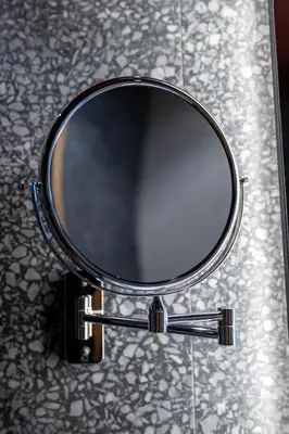 a mirror sitting on top of a bathroom counter at Hotel Helm in Niš