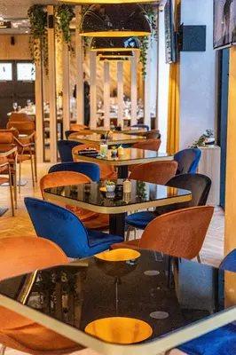 a restaurant with tables and chairs in a room at Hotel Helm in Niš