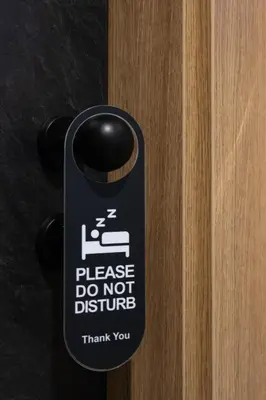 a sign on a door that says please do not disturb at Hotel Helm in Niš