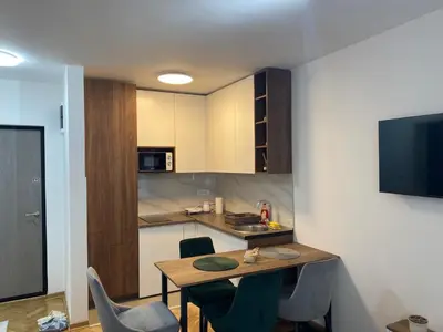 a small kitchen with a table and chairs in a room at Apartman MM Vrnjacka Banja in Vrnjci