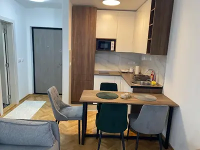 a kitchen with a table and chairs in a room at Apartman MM Vrnjacka Banja in Vrnjci