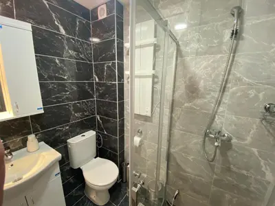 a bathroom with a shower and a toilet and a sink at Apartman MM Vrnjacka Banja in Vrnjci