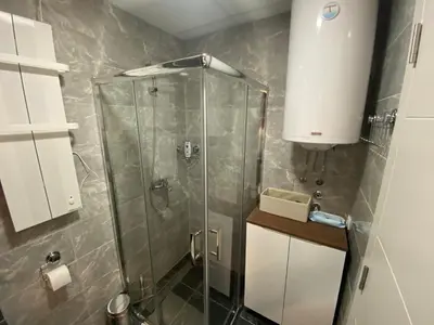 a shower stall with a glass door in a bathroom at Apartman MM Vrnjacka Banja in Vrnjci