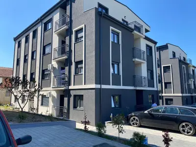 a building with a car parked in front of it at Apartman MM Vrnjacka Banja in Vrnjci