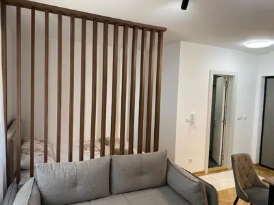 a living room with a couch and a striped wall at Apartman MM Vrnjacka Banja in Vrnjci