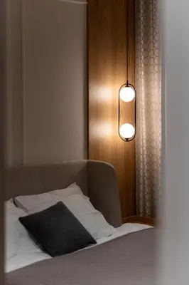 a bedroom with a bed and a light and a lamp at Planet Residence NiNa in Niš