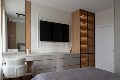 a bedroom with a bed and a television on a wall at Planet Residence NiNa in Niš