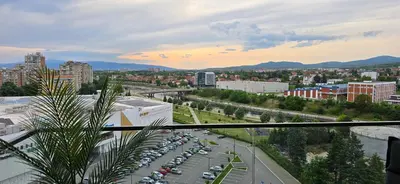 a city with cars parked in a parking lot at Planet Residence NiNa in Niš