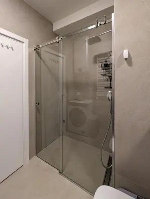 a shower with a glass door in a bathroom at Planet Residence NiNa in Niš