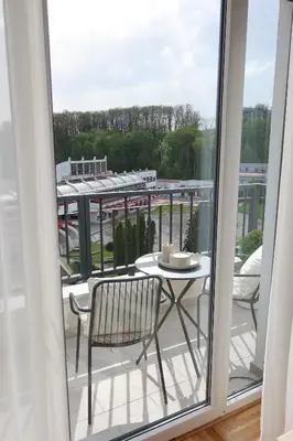 a table and chair on a balcony with a view at Banja Maison in Vrnjačka Banja
