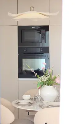 a kitchen with an oven and a table with flowers at Banja Maison in Vrnjačka Banja