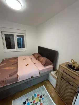a small bedroom with a bed and a window at Apartman Stević in Vrnjci
