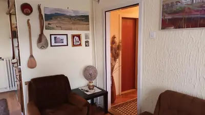 a living room with a chair and a table with a lamp at Apartman19 Resavica in Železnička Stanica Resavica