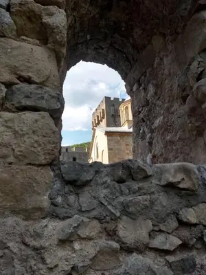 a view of a castle through a stone wall at Apartman19 Resavica in Železnička Stanica Resavica