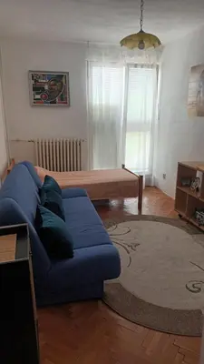a living room with a blue couch and a table at Apartman19 Resavica in Železnička Stanica Resavica
