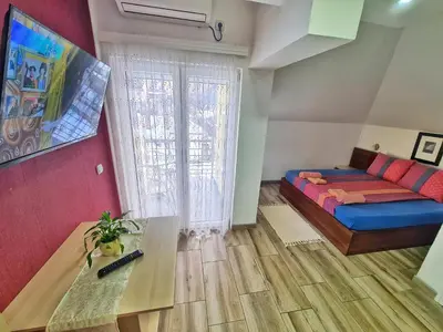 a bedroom with a bed and a table and a window at Vila Aleksandra 2 Studio 16 in Soko Banja