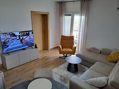 a living room with a couch and a flat screen tv at MIL apartment Sokobanja in Soko Banja