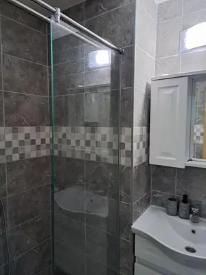 a bathroom with a glass shower and a sink at MIL apartment Sokobanja in Soko Banja