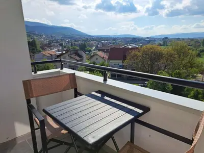a table and chairs on a balcony with a view at MIL apartment Sokobanja in Soko Banja