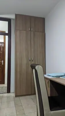 a desk with two chairs and a desk with cabinets at Mirage Apartments in Niš