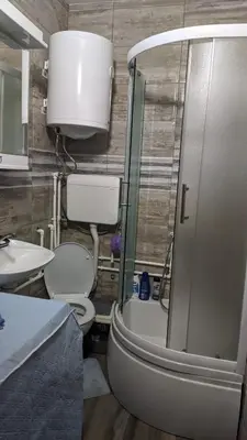 a bathroom with a toilet and a sink and a shower at Mirage Apartments in Niš