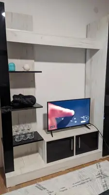 a living room with a flat screen tv on a shelf at Mirage Apartments in Niš