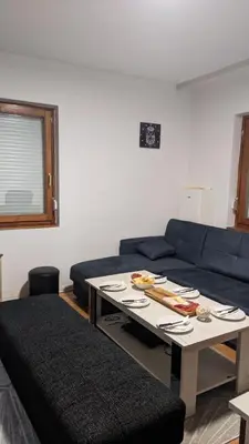 a living room with a blue couch and a table at Mirage Apartments in Niš