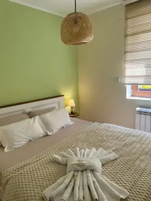 a bedroom with a bed with a towel on it at Apartman Korićanac I Vrnjačka Banja in Vrnjačka Banja