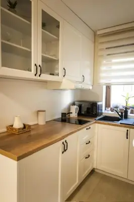 a kitchen with white cabinets and a wooden counter top at Apartman Korićanac I Vrnjačka Banja in Vrnjačka Banja