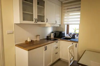 a kitchen with white cabinets and a counter top at Apartman Korićanac I Vrnjačka Banja in Vrnjačka Banja