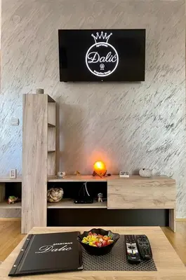 a room with a table with a tv on a wall at Apartman Đalić in Vrnjačka Banja