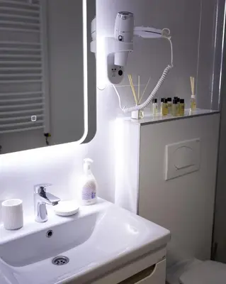 a white bathroom with a sink and a mirror at Apartman Korićanac II Vrnjačka Banja in Vrnjačka Banja